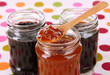 Tasty jam in banks on table close-up
