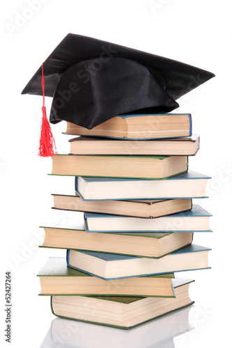 Photo: Grad hat with books isolated on white Grad hat with books isolated on white