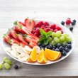 Foto: Fruits and berries on a white plate Fruits and berries on a white plate