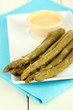 Asparagus on plate, on wooden background