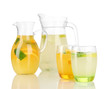 Orange and lemon lemonade in pitchers and glasses isolated