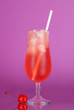 Cherry cocktail with ice on purple background