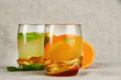 Lemonade in glasses on fabric background close-up