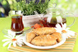 Sweet baklava on plate with tea on table on bright background