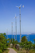 Series of wind power generators in clear blue sky background.
