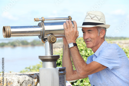 Photo: Man looking through telescope Man looking through telescope