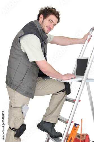 Photo: Handyman stood with laptop Handyman stood with laptop