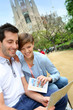 Couple reading travel guide by the sagrada familia church