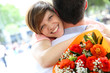 Portrait of cheerful girl holding bunch of flowers