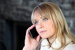 Blond woman making telephone call from home