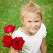 Photo: happy child with a bouquet of red roses happy child with a bouquet of red roses