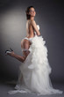 Young cheerful bride posing in white lingerie