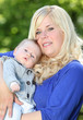 Photo: Young mother with her little boy in the park together. Young mother with her little boy in the park together.