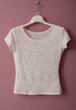 Transparent white blouse is on hanger.