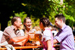 Foto: Im Biergarten - Freunde trinken Bier in Bayern Im Biergarten - Freunde trinken Bier in Bayern