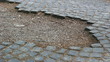 People walking on damaged pavement