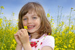 happy little girl with rapeseed flower