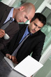 Businessmen looking at a laptop