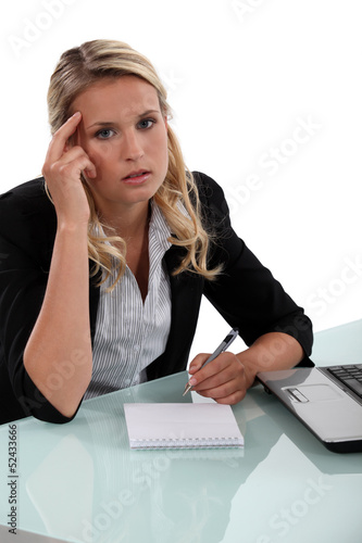 Photo: Pensive businesswoman writing notes Pensive businesswoman writing notes