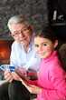 Photo: Old man playing card game with his granddaughter Old man playing card game with his granddaughter