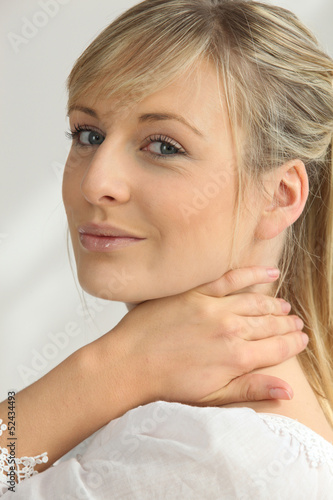 Photo: Blonde woman with hand on neck Blonde woman with hand on neck