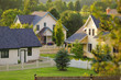 Three rural homes with white picket fences.