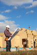 Foreman overlooking construction of wooden house
