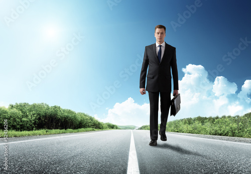 Photo: business man walking on the road business man walking on the road