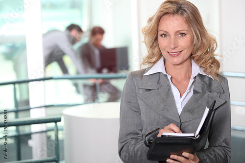 Photo: Businesswoman writing in her agenda Businesswoman writing in her agenda