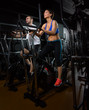 elliptical walker trainer man and woman at black gym