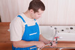 Foto: Plumber fitting a tap on a kitchen sink Plumber fitting a tap on a kitchen sink