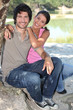 Photo: Couple sitting by a pond Couple sitting by a pond