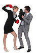 businesswoman threatening male colleague with boxing gloves