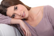 Brunette leaning on sofa