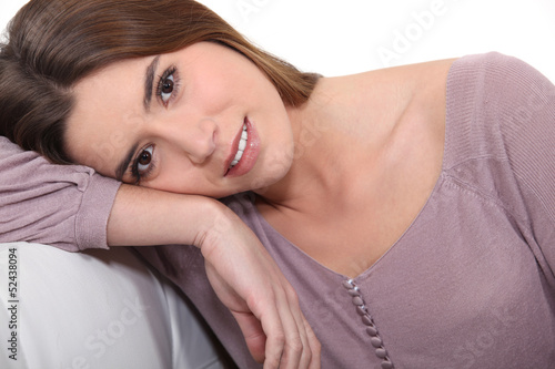Photo: Brunette leaning on sofa Brunette leaning on sofa