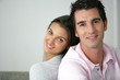 Foto: Young couple sitting back to back Young couple sitting back to back