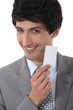 Confident businessman holding calling card