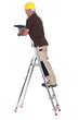 Photo: Tradesman standing on a stepladder and using a power tool Tradesman standing on a stepladder and using a power tool