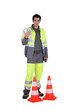 Traffic worker stood by cone