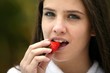 Photo: Brunette eating a delicious strawberry Brunette eating a delicious strawberry