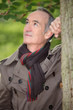 Foto: Retired man leaning against a tree Retired man leaning against a tree