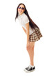 Modest school girl in plaid skirt and sneakers