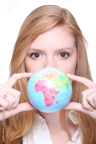 Photo: young woman showing a little globe young woman showing a little globe