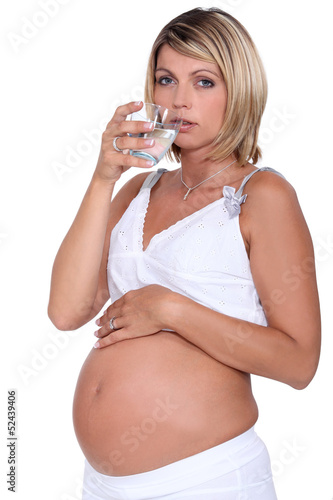 Photo: Pregnant woman drinking a glass of water Pregnant woman drinking a glass of water