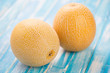 Horizontal shot of two ripe Galia melons on wooden boards