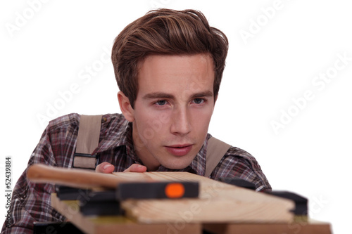 Photo: Carpenter aligning plank of wood Carpenter aligning plank of wood