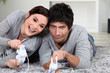 Foto: Couple laying on rug playing video games Couple laying on rug playing video games