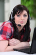 Photo: Woman laid in front of laptop with headset Woman laid in front of laptop with headset