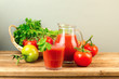 Tomato juice and tomatoes on wooden deck table