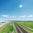 railroad in green fields and blue sky